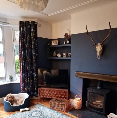 Navy living room with log burner and dear head on the wall, featuring BHS ceiling light
